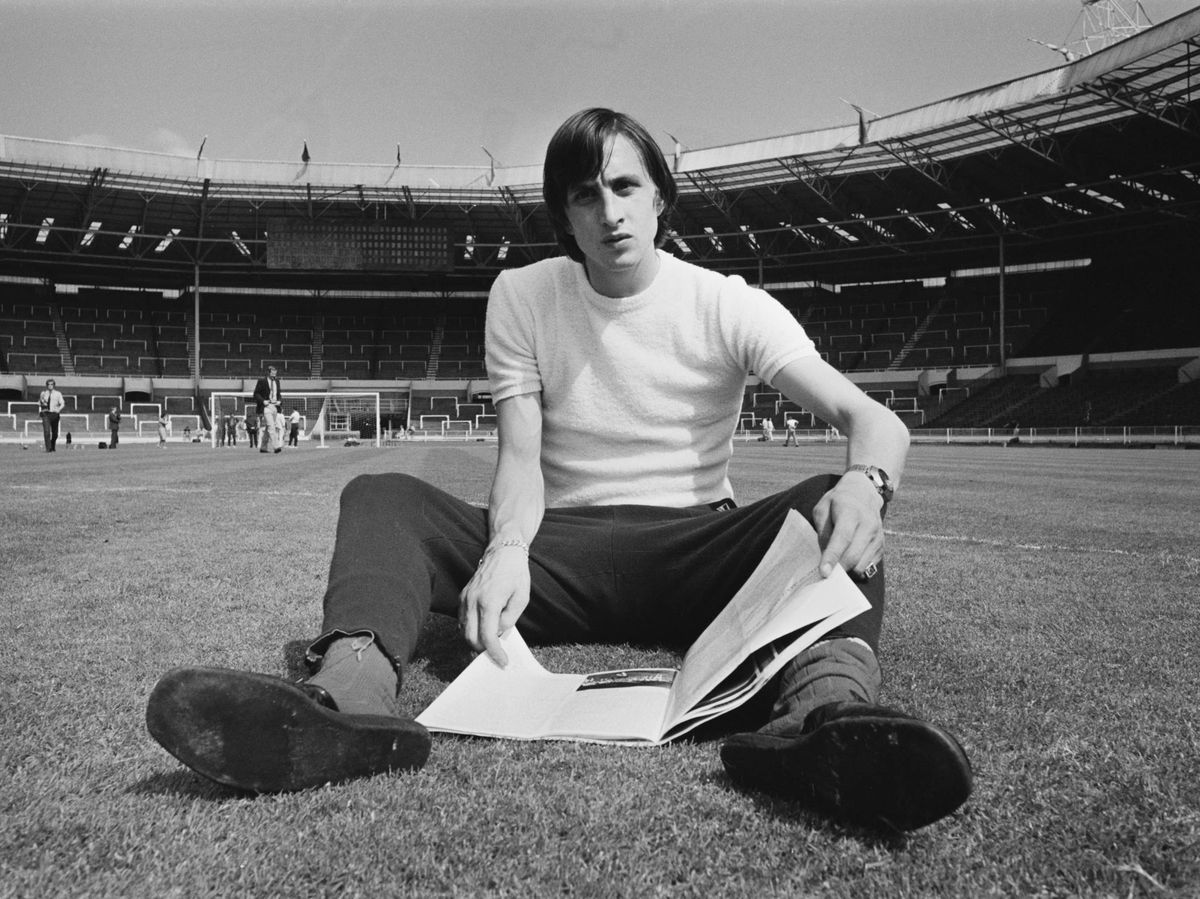 Foto retro de Cruyff sentado en el cesped de un estadio